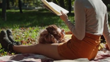 İki mutlu genç kadın şehir parkında otururken eğleniyor. Genç ve mutlu bir hayat. Bir kız kitap okur, ikincisi ayaklarının üstünde yatar..