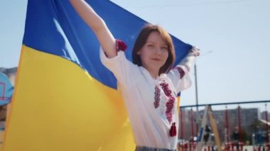 Ukrayna bayrağı ve bir işaret taşıyan neşeli bir Ukraynalı kadının portresi. Kız, savaştan kalan kocasını bekliyor. Rusya ile Ukrayna arasındaki savaş.