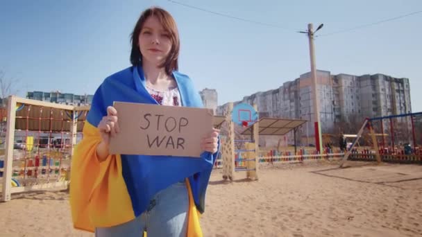 Portret van een vrolijke Oekraïense vrouw met een Oekraïense vlag en een bord. Het meisje wacht op haar man uit de oorlog. Oorlog tussen Rusland en Oekraïne. — Stockvideo