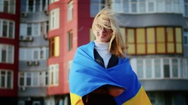 Ukrayna bayrağı ve bir işaret taşıyan neşeli bir Ukraynalı kadının portresi. Kız, savaştan kalan kocasını bekliyor. Rusya ile Ukrayna arasındaki savaş.