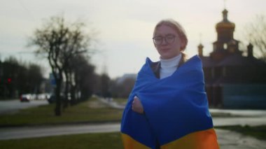 Ukrayna bayrağı ve bir işaret taşıyan neşeli bir Ukraynalı kadının portresi. Kız, savaştan kalan kocasını bekliyor. Rusya ile Ukrayna arasındaki savaş.