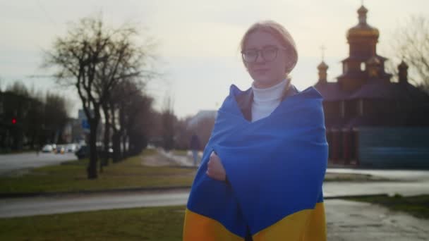 Retrato de una alegre mujer ucraniana sosteniendo una bandera ucraniana y un cartel. La chica está esperando a su marido de la guerra. Guerra entre Rusia y Ucrania. — Vídeos de Stock