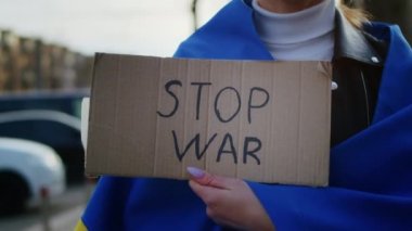 Ukrayna bayrağı ve bir işaret taşıyan neşeli bir Ukraynalı kadının portresi. Kız, savaştan kalan kocasını bekliyor. Rusya ile Ukrayna arasındaki savaş.