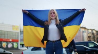 Ukrayna bayrağı ve bir işaret taşıyan neşeli bir Ukraynalı kadının portresi. Kız, savaştan kalan kocasını bekliyor. Rusya ile Ukrayna arasındaki savaş.