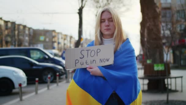 Ukrayna bayrağı ve bir işaret taşıyan neşeli bir Ukraynalı kadının portresi. Kız, savaştan kalan kocasını bekliyor. Rusya ile Ukrayna arasındaki savaş. — Stok video
