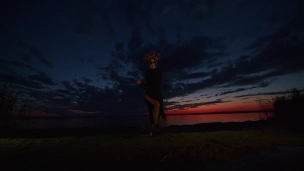 Szczęśliwa młoda kobieta w kostiumie halloween i makijaż tańczy w naturze podczas zachodu słońca, mistyczny materiał. — Wideo stockowe