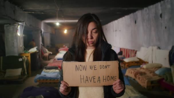 Portrait d'une femme arménienne triste, dans un grand abri à bombes, tenant un signe. Guerre entre la Russie et l'Ukraine. — Video