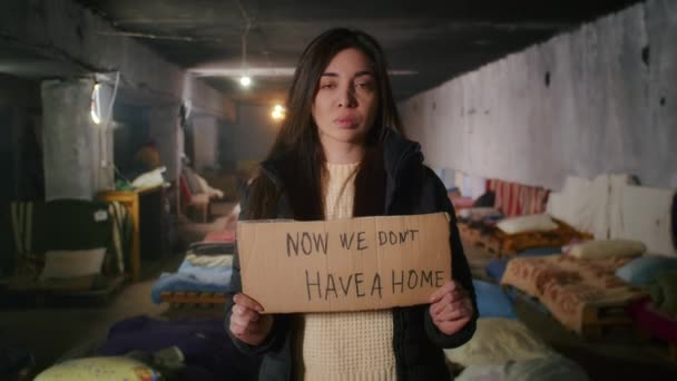 Retrato de una mujer armenia triste, en un gran refugio antibombas, sosteniendo un cartel. Guerra entre Rusia y Ucrania. — Vídeos de Stock