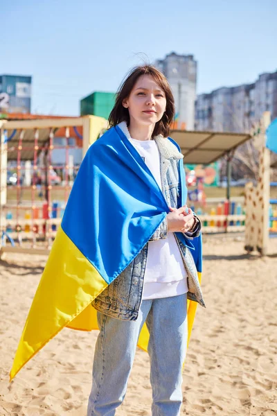 Porträtt av en glad ukrainsk kvinna med ett barn och en ukrainsk flagga. Flickan väntar på sin man från kriget. Krig mellan Ryssland och Ukraina. — Stockfoto