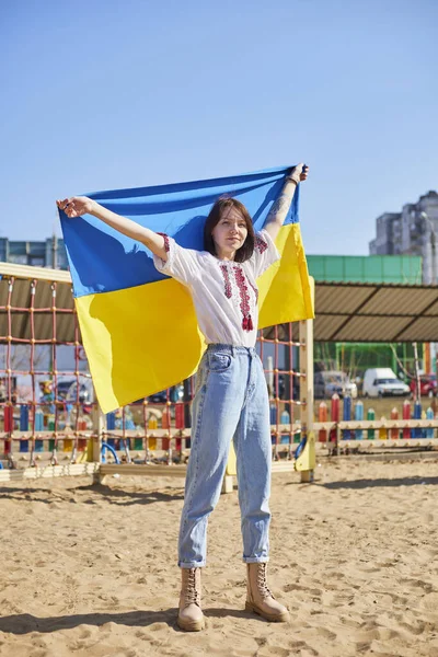 Портрет радостной украинки с ребенком и украинским флагом. Девушка ждет своего мужа с войны. Война между Россией и Украиной. — стоковое фото