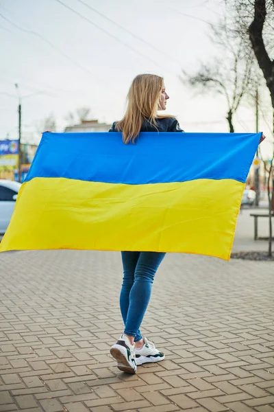 Portrait d'une femme ukrainienne joyeuse tenant un drapeau ukrainien et un signe. La fille attend son mari de la guerre. Guerre entre la Russie et l'Ukraine. — Photo