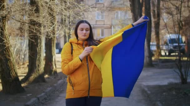 Portrét smutné ukrajinské ženy s ukrajinskou vlajkou a znakem. Ta dívka čeká na svého manžela z války. Válka mezi Ruskem a Ukrajinou. — Stock video