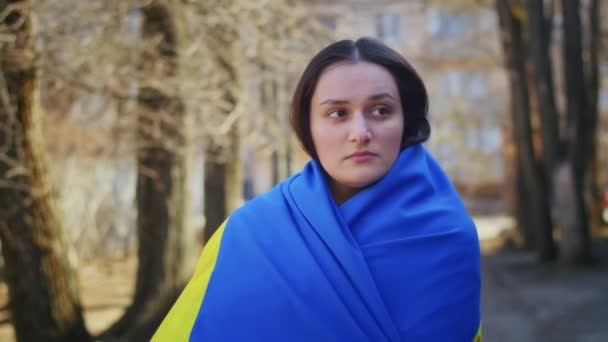 Porträt einer traurigen Ukrainerin mit einer ukrainischen Flagge und einem Schild. Das Mädchen wartet auf ihren Mann aus dem Krieg. Krieg zwischen Russland und der Ukraine. — Stockvideo
