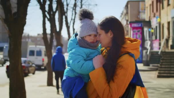 Ritratto di una triste donna ucraina con un bambino e la bandiera ucraina. La ragazza sta aspettando suo marito dalla guerra. Guerra tra Russia e Ucraina. — Video Stock