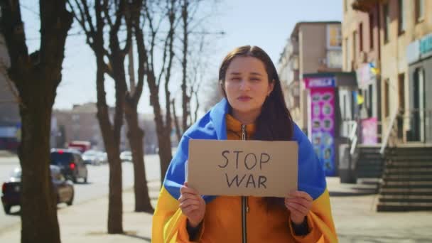우크라이나 국기와 간판을 들고 있는 슬픈 우크라이나 여성의 초상화. 그 소녀는 전쟁에서 남편을 기다리고 있다. 러시아와 우크라이나 사이의 전쟁. — 비디오