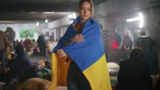 방공호에서 우크라이나 국기를 들고 있는 슬픈 우크라이나 여성의 모습. 그 소녀는 전쟁에서 남편을 기다리고 있다. 러시아와 우크라이나 사이의 전쟁. — 비디오