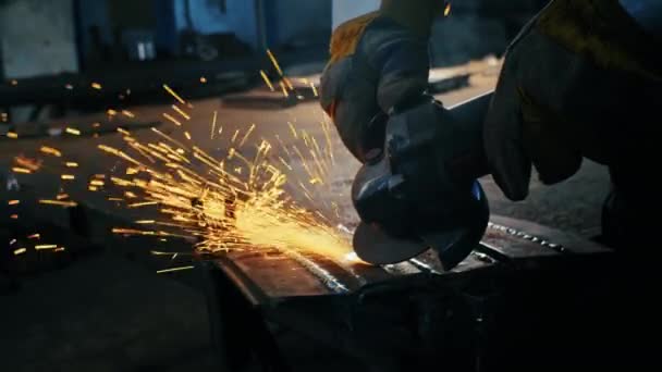 Montaż konstrukcji metalowych, wykonanie samodzielnie wykonanej płyty pancernej przez profesjonalnego pracownika za pomocą szlifierki. Prace szlifierskie z gładkim wyposażeniem do stali, żelaza, iskier w ciężkich — Wideo stockowe
