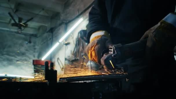 Assemblage de structures métalliques, fabrication d'une plaque de blindage auto-fabriquée par un travailleur professionnel à l'aide d'une rectifieuse. Travaux de meulage avec des équipements lisses pour l'acier métal, fer, étincelles dans un lourd — Video