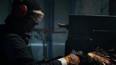 Metal yapılar monte etmek, öğütme makinesi kullanan profesyonel bir işçi tarafından ev yapımı ısıtıcı yapmak. Çelik metal, demir ve ağır sanayi fabrikasında kıvılcımlar saçan pürüzsüz ekipmanlarla öğütme işi