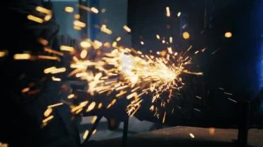 Metal yapılar monte etmek, öğütme makinesi kullanan profesyonel bir işçi tarafından ev yapımı ısıtıcı yapmak. Çelik metal, demir ve ağır sanayi fabrikasında kıvılcımlar saçan pürüzsüz ekipmanlarla öğütme işi