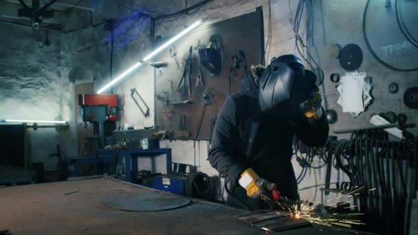 Porträtt av en trött fabriksarbetare. stålkonstruktionssvetsning, gör hemmagjord pansarplåt av professionell arbetare med hjälp av svetsmaskin, järnsvetsning, gnistor i tung industri fabrik inomhus — Stockvideo