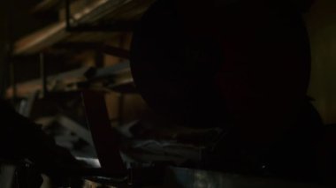 Bir adam yaydan çıkan kurşun geçirmez yelek için metal bir parça kesiyor. Ev yapımı zırh plakası. Fabrika işçisi metali keser. Adam kesiyor. Endüstriyel öğütücüyle kesmek. Kıvılcımlar ve parıltılar uçuşuyor