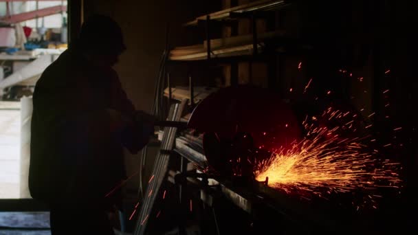 Primer plano, un hombre corta una pieza de metal para un chaleco a prueba de balas de muelles. placa de armadura casera. Trabajador de fábrica corta metal. El hombre está cortando. corte con amoladora industrial. Chispas y destellos vuelan — Vídeo de stock