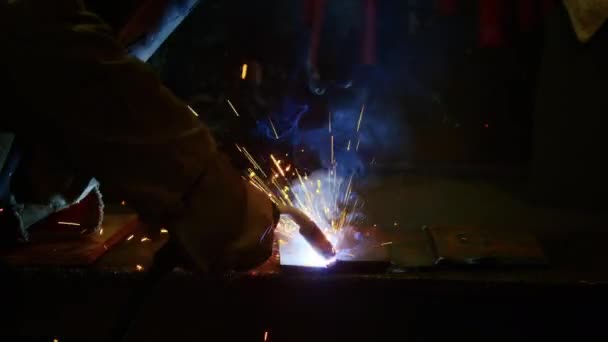 De cerca, un hombre suelda placas para armaduras de resortes. placa de armadura casera. Trabajador de fábrica suelda metal. El hombre está soldando. Soldadura con argón o electrodo, utilizando una máquina de soldadura. Chispas y — Vídeos de Stock