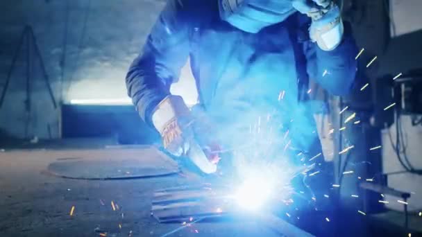 Shot of a tired worker in a factory. steel structure welding, making homemade armor plate by professional worker using welding machine, iron welding, sparks in heavy industry factory indoors. conflict — Stock Video