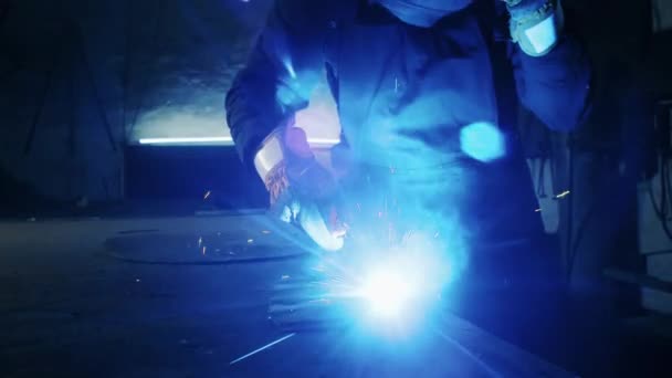 Disparo de un trabajador cansado en una fábrica. soldadura de la estructura de acero, haciendo la placa casera de la armadura por el trabajador profesional usando la soldadora, soldadura de hierro, chispas en la fábrica de la industria pesada en el interior. conflicto — Vídeo de stock