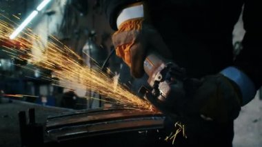 Metal yapıları birleştirmek, öğütme makinesi kullanan profesyonel bir işçinin kendi yaptığı bir zırh plakası yapmak. Çelik metal, demir ve ağır kıvılcımlar için pürüzsüz ekipmanlarla öğütme işi