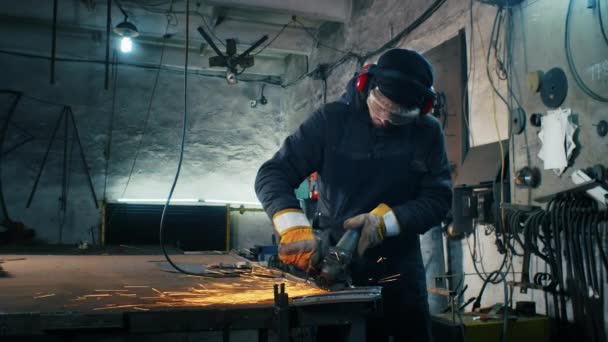 Metal yapıları birleştirmek, öğütme makinesi kullanan profesyonel bir işçinin kendi yaptığı bir zırh plakası yapmak. Çelik metal, demir ve ağır kıvılcımlar için pürüzsüz ekipmanlarla öğütme işi — Stok video