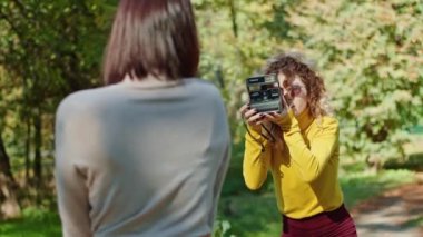 Krivoy Rog, Ukrayna - 10 Eylül 2021 mutlu genç kız şehir parkının arka planında arkadaşı fotoğrafçıya poz veriyor. gençlik ve güzellik.