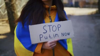 Ukrayna bayrağı ve tabelası olan üzgün bir Ukraynalı kadının portresi. Kız, savaştan kalan kocasını bekliyor. Rusya ile Ukrayna arasındaki savaş.