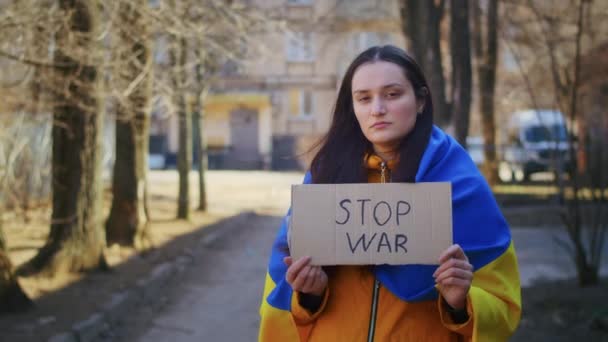 Portret van een droevige Oekraïense vrouw met een Oekraïense vlag en een teken. Het meisje wacht op haar man uit de oorlog. Oorlog tussen Rusland en Oekraïne. — Stockvideo