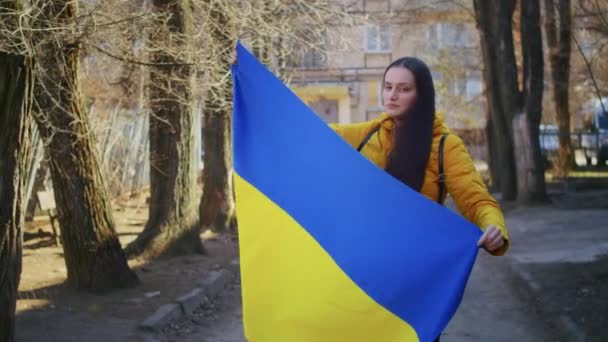 Ukrayna bayrağı ve tabelası olan üzgün bir Ukraynalı kadının portresi. Kız, savaştan kalan kocasını bekliyor. Rusya ile Ukrayna arasındaki savaş. — Stok video