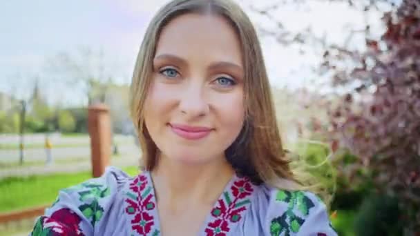 Mulher feliz se alegra com o pano de fundo de flores sakura rosa florescendo. Passeio de fim de semana com um sorriso ao pôr do sol. mulher e primavera. — Vídeo de Stock