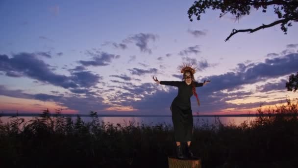 Happy young woman in halloween costume and makeup dances in nature during sunset, mystical footage. — Stockvideo