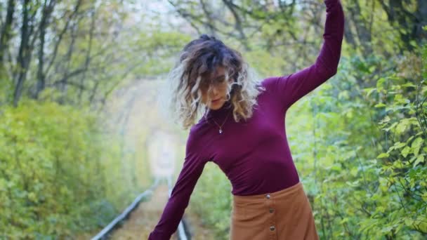 Gelukkige jonge vrouwelijke toerist spinnen in de tunnel van de liefde met herfstbladeren, ademen frisse lucht, haar fladderen in de wind, mensen vrijheid concept. geluk. — Stockvideo