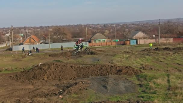 Kryvyi Rih, Ukraine - October, 24, 2021 Shot of the professional motocross rider on his motorcycle on the extreme terrain track. Biker flying on a motocross motorcycle. Construction background and sky — Video Stock