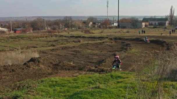 Kryvyi Rih, Ukraine - October, 24, 2021 Shot of the professional motocross rider on his motorcycle on the extreme terrain track. Biker flying on a motocross motorcycle. Construction background and sky — Stock Video