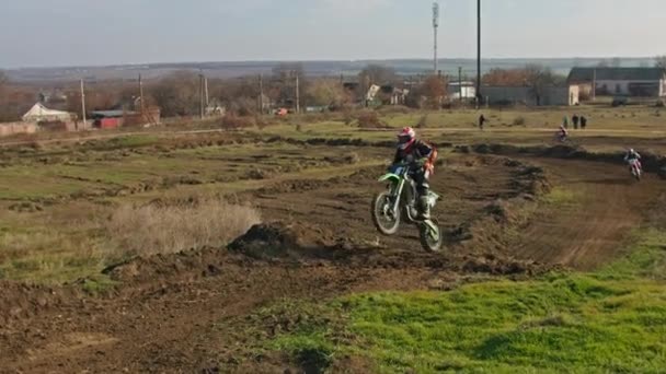 Kryvyi Rih, Ukraine - October, 24, 2021 Shot of the professional motocross rider on his motorcycle on the extreme terrain track. Biker flying on a motocross motorcycle. Construction background and sky — Video