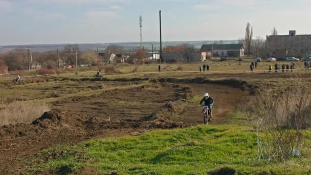 Kryvyi Rih, Ukraine - October, 24, 2021 Shot of the professional motocross rider on his motorcycle on the extreme terrain track. Biker flying on a motocross motorcycle. Construction background and sky — Wideo stockowe