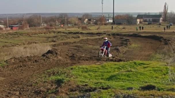 Kryvyi Rih, Ukraine - October, 24, 2021 Shot of the professional motocross rider on his motorcycle on the extreme terrain track. Biker flying on a motocross motorcycle. Construction background and sky — Stock Video