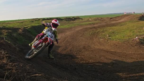 Kryvyi Rih, Ukraine - October, 24, 2021 Shot of the professional motocross rider on his motorcycle on the extreme terrain track. Biker flying on a motocross motorcycle. Construction background and sky — ストック動画