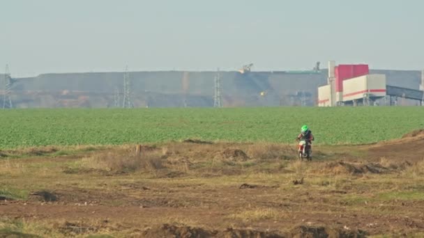 Kryvyi Rih, Ukraine - October, 24, 2021 Shot of the professional motocross rider on his motorcycle on the extreme terrain track. Biker flying on a motocross motorcycle. Construction background and sky — Vídeos de Stock