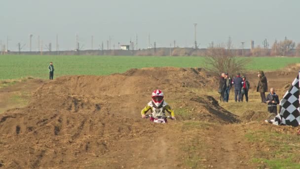 Kryvyi Rih, Ucrania - 24 de octubre de 2021 Disparo del motocross profesional en su motocicleta en la pista de terreno extremo. Motociclista volando en una motocicleta de motocross. Fondo de construcción y cielo — Vídeo de stock