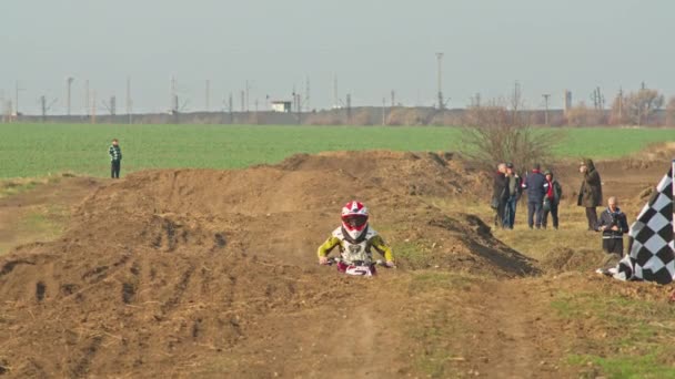 Kryvyi Rih, Ukraine - October, 24, 2021 Shot of the professional motocross rider on his motorcycle on the extreme terrain track. Biker flying on a motocross motorcycle. Construction background and sky — Wideo stockowe