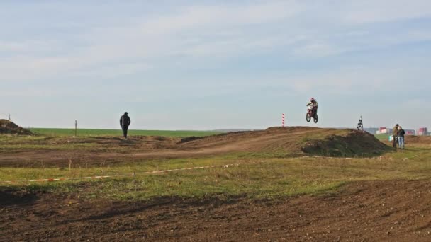 Kryvyi Rih, Ukraine - October, 24, 2021 Shot of the professional motocross rider on his motorcycle on the extreme terrain track. Biker flying on a motocross motorcycle. Construction background and sky — 비디오