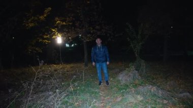 cinematic shot, a man walks through a dark forest, a creepy zombie woman runs out of the darkness and attacks. horror. halloween. real evil.